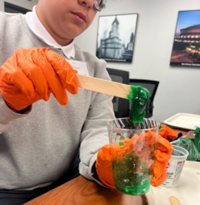 Student creating green slime