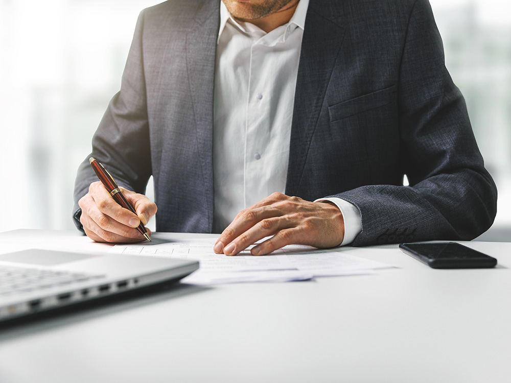 businessman signing business contract papers in bright modern coworking office. copy space