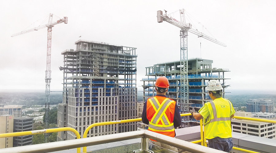 Construction workers survey a job site